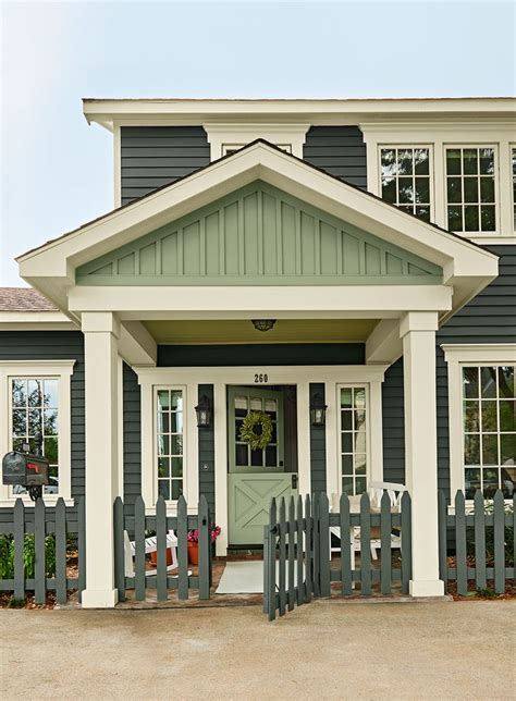 a gray and white house with a green door