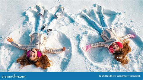 Winter Angels. Happy Kids Girls on Make Snow Angel Wings. Two Children ...