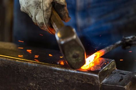 Premium Photo | A blacksmith forging hot iron on the anvil.