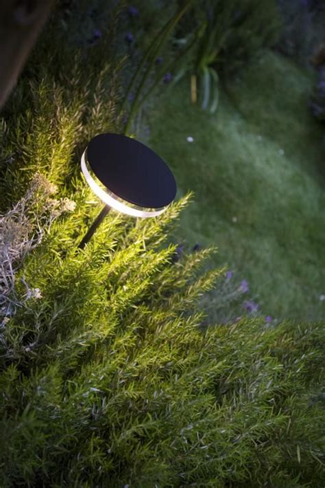 a black table sitting in the grass next to a light on it's side