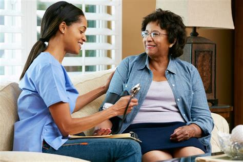 two women sitting on a couch talking to each other while one holds a clipboard in her hand