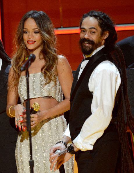 Rihanna cosies up to ziggy and damian marley as they take time out from ...