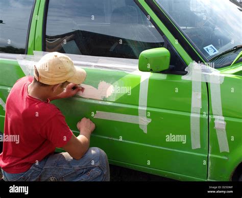 Young boy repair green color car body sanding putty Stock Photo - Alamy