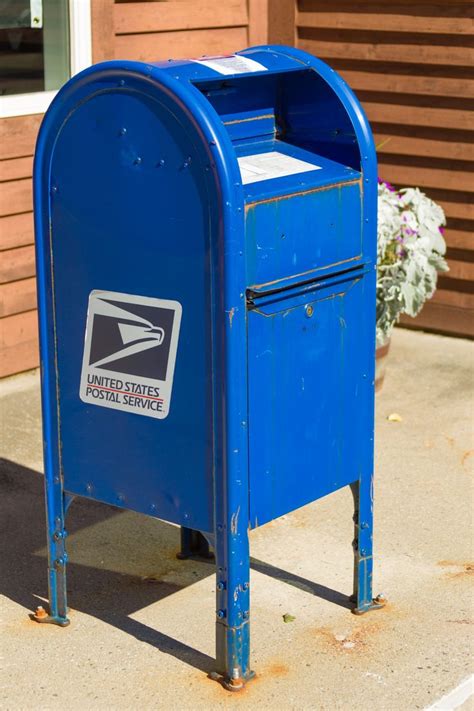 a blue mailbox sitting on the side of a building