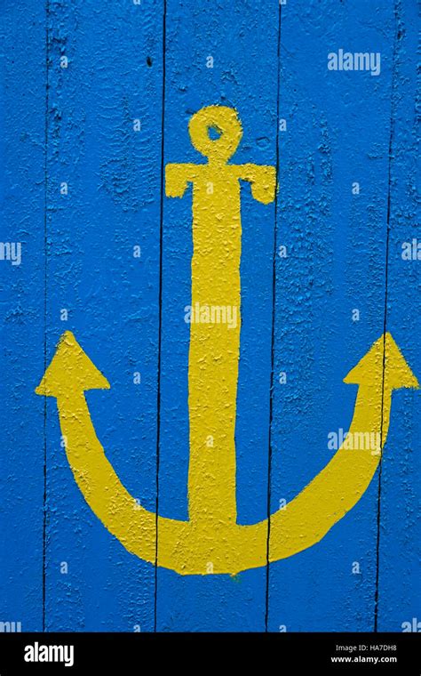 Yellow anchor on a blue background Stock Photo - Alamy