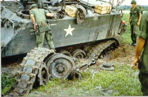 U.S soldiers inspect a damaged M113 APC after a mine blew out its ...