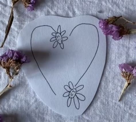 a paper heart with a drawing of a bee on it next to dried lavenders