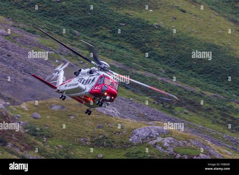 HM Coastguard helicopter operating in Snowdonia, North Wales Stock Photo - Alamy