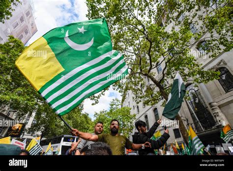 London, UK. 15 August 2019. A man waves a Kashmiri flag as thousands of ...