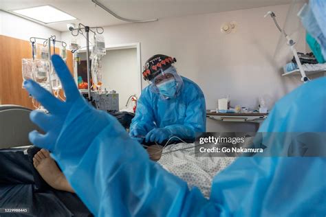 Dr. Joseph Varon, center, and other medical staff members check up on ...