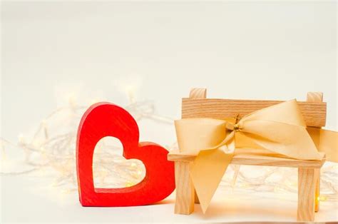 Premium Photo | Wooden heart with a bow on a bench on a white background valentines day