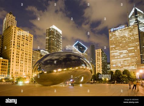 Anish Kapoor sculpture Cloud Gate aka the Bean at night with city behind Millennium Park in ...