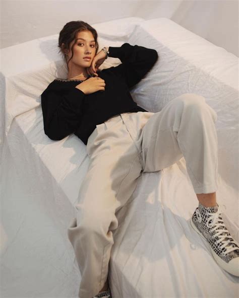 a person laying on a bed with white sheets