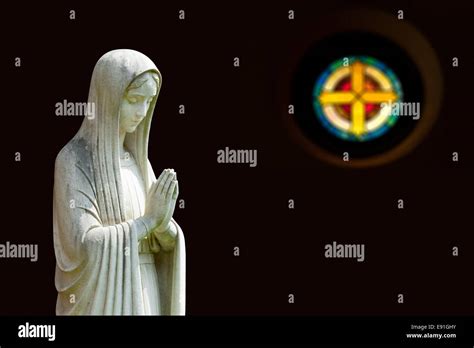 Isolated statue of Mary with cross Stock Photo - Alamy