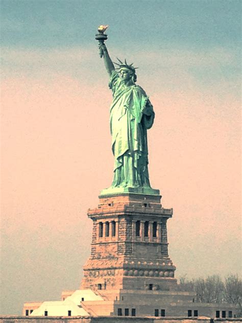 the statue of liberty stands in front of a body of water