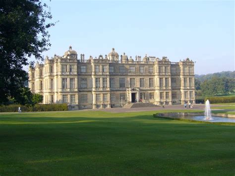 a large building with a fountain in front of it on a green field next ...