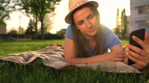 Girl making a selfie lying down on a blanket in the park at sunset 22703461 Stock Video at Vecteezy