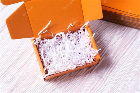 Premium Photo | Orange cardboard box with white shredded paper filler