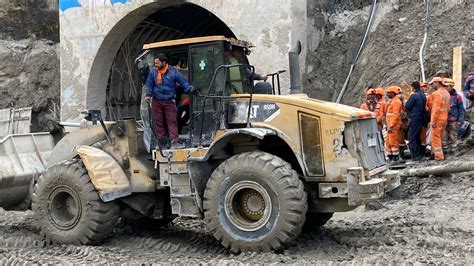 India: Rescuers try to reach workers trapped in tunnel as relatives ...