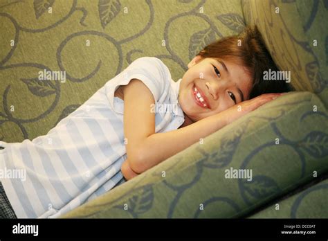 Little girl lying on couch Stock Photo - Alamy