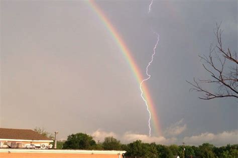 A double rainbow appears in the sky as lightning strikes during a ...