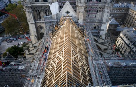 notre-dame’s spire is finally installed, one year before the cathedral’s scheduled opening