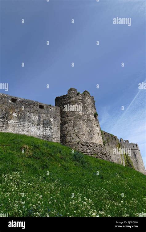 The sun hits the side of Marten's Tower, Chepstow Castle. Contrails make a pattern in a clear ...