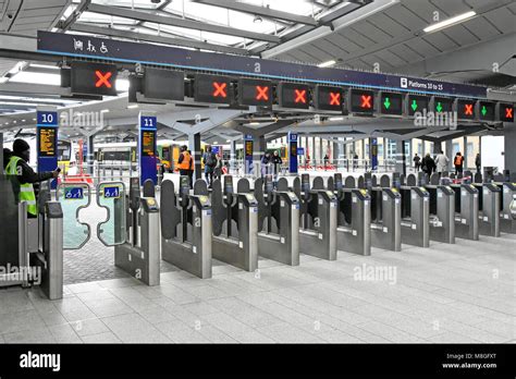 Train station ticket barriers gate across train platform big bold green open red closed access ...