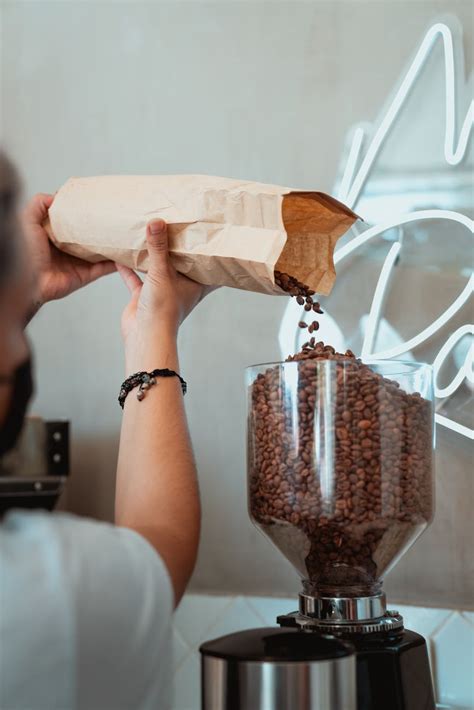 Photo of Person Pouring Coffee Beans on a Coffee Grinder · Free Stock Photo