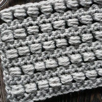 a crocheted dishcloth is sitting on a wooden table next to a pair of scissors