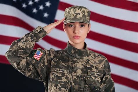 Female American soldier saluting with flag of USA on background ...