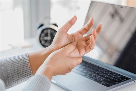 Closeup woman holding her hand pain from using laptop computer long ...