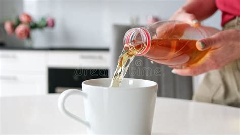 Girl Pouring Apple Juice into Glass in the Kitchen, in Slow Motion ...