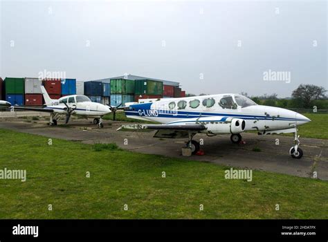 Decaying planes stored at North Weald airfield, Essex, UK, with stacks of shipping containers ...