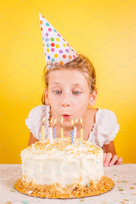 Kid blowing out candles on bday cake | High-Quality Holiday Stock Photos ~ Creative Market