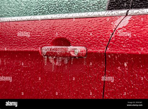 Closeup of car door handle and lock covered in ice during winter storm ...