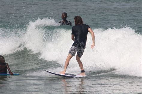 A Tourist is Enjoy Surfing in Lagos Beach while Two Admirers Watch ...