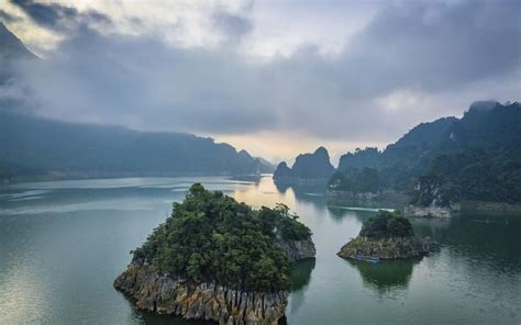 an island in the middle of water surrounded by mountains