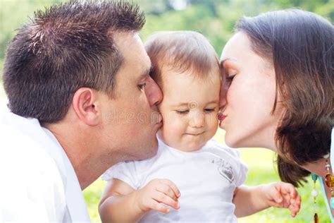 Parents kissing baby stock photo. Image of female, laughing - 13554912