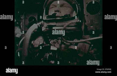 1960s: John Glenn sits in space shuttle capsule. Tracking screen ...