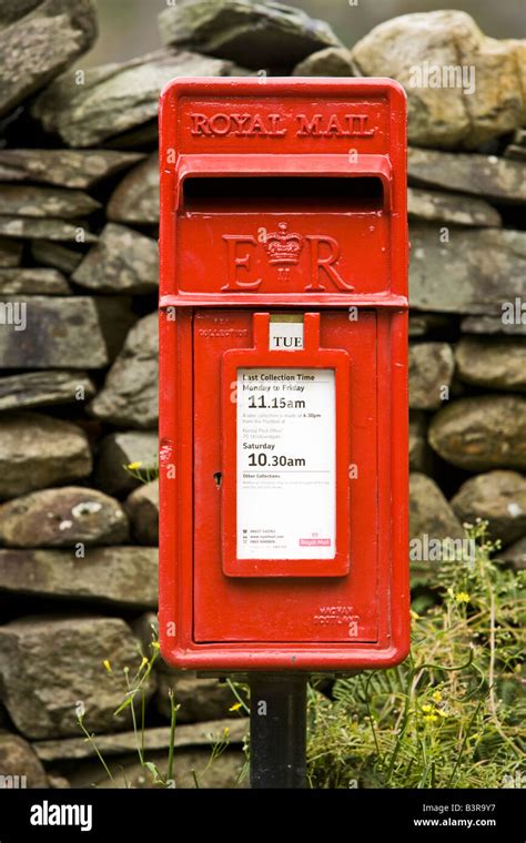 Traditional red Royal Mail post letter box and dry stone wall in rural ...