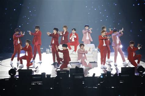 a group of people standing on top of a stage with their hands in the air