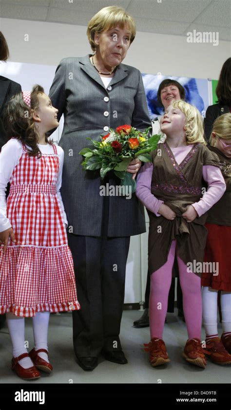 German Chancellor Angela Merkel poses with children during the opening of the 'Wellcome center ...