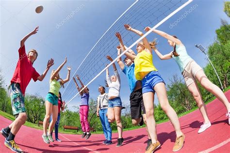 Teens playing volleyball on ground Stock Photo by ©serrnovik 77385760