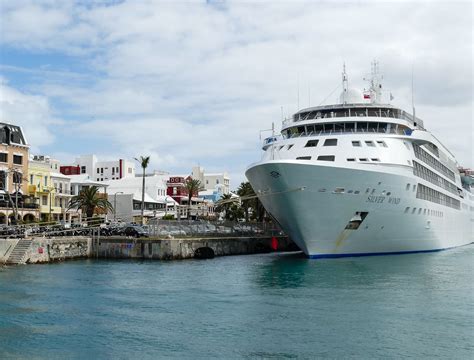 a cruise ship is docked in the water next to some buildings and palm trees on either side