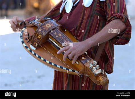 Man dressed in French period Troubadour costume playing a hurdy gurdy Stock Photo - Alamy