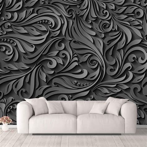 a couch sitting in front of a wall covered in black and white art nouveau designs