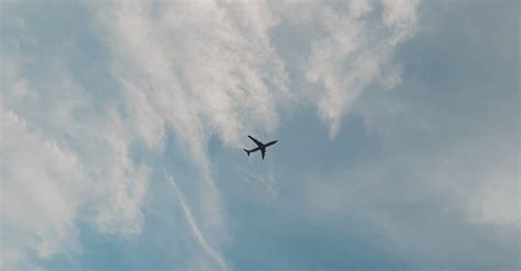 Photo of an Airplane Under White Clouds · Free Stock Photo