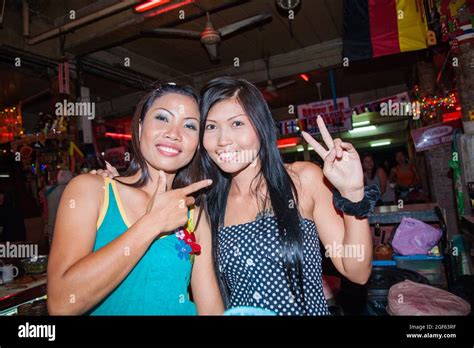 Two pretty Thai bar girls give peace sign posing for photo, Pattaya, Thailand Stock Photo - Alamy