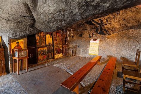 the inside of a cave with benches and paintings